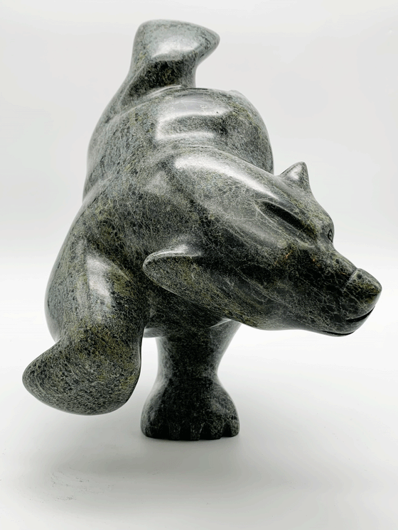 This large bear plunges into the water. The piece is balanced to stand on one forepaw, its other three legs are raised as though paddling. Its head strains as though reaching for a fish. This bear faces the viewer.
