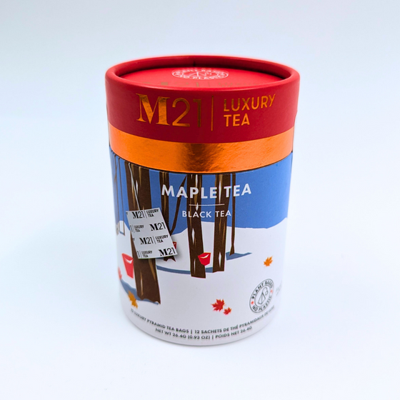 A cylindrical box that holds twelve maple flavoured tea bags. The tea bags are pyramid shaped and are blended and packed in Canada. The container is made from 100% recycled paper. The illustration on the canister depicts a Canadian winter forest scene with maple trees. Red buckets hang from the trees representing the maple syrup harvest and maple leaves scatter the ground.  The red imagery matches the red coloured lid. It includes instructions to brew for three to five minutes. 