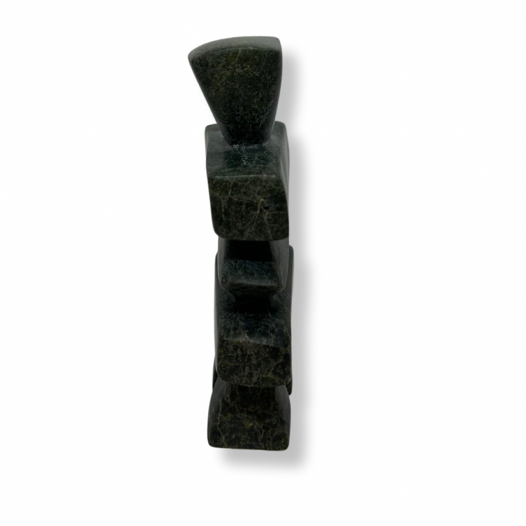 A squat, squarish inukshuk carved from green and black stone.