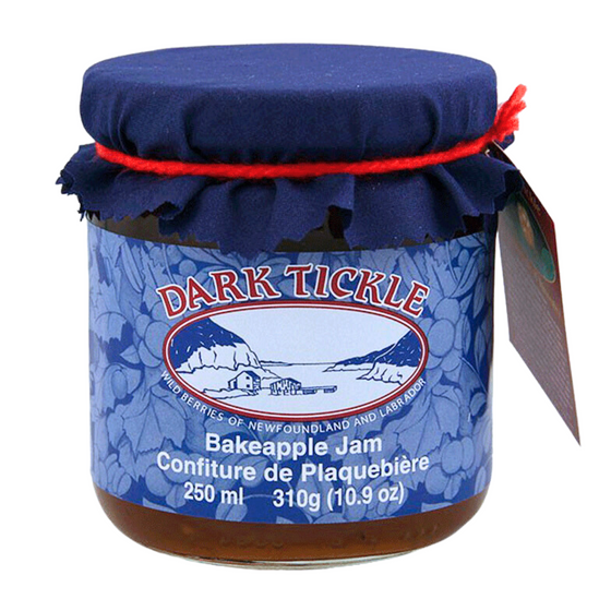 Glass Jar of Bakeapple jam from Dark Tickle in Newfoundland. Jam is orange/ yellow in color, and shut sealed with a tin lid. 