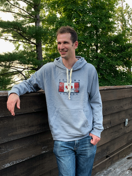 A grey hoodie with white drawstrings. A Canadian flag with a navy border is printed on the chest, with Ottawa written above and Canada written below.