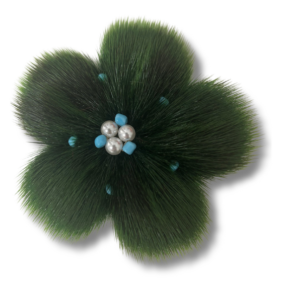 sealskin in the shape of a dark green flower, with several pearl like circles in the center.