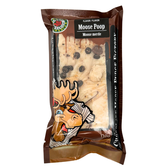 Rectangular Fudge Bar made in Canada Inside of a plastic package. There is a cartoon Moose on the cover of the package, and big writing saying 'Chocolate Moose Fudge Factory'. Flavor of the fudge is chocolate chip cookie dough. Fudge is brown and white with pieces of cookies on top of it.