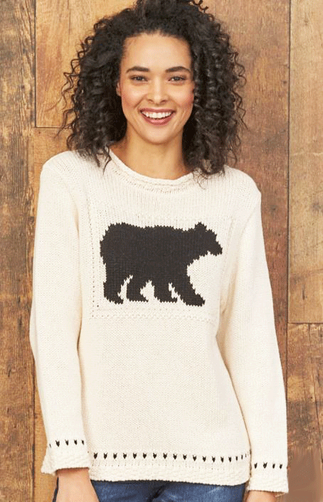 A white crewneck sweater with a black bear silhouette on the chest. Black spots are around the end of each arm and the bottom of the sweater. 