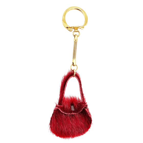 A red sealskin purse keychain. The keychain hardware is gold.