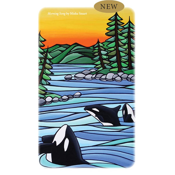 A rectangular tin box with Misha Smart's artwork titled Morning Song printed on the lid. The image depicts 3 orca whales in blue flowing water, with a rocky shoreline, green trees and hills, and an orange and yellow sunset above.