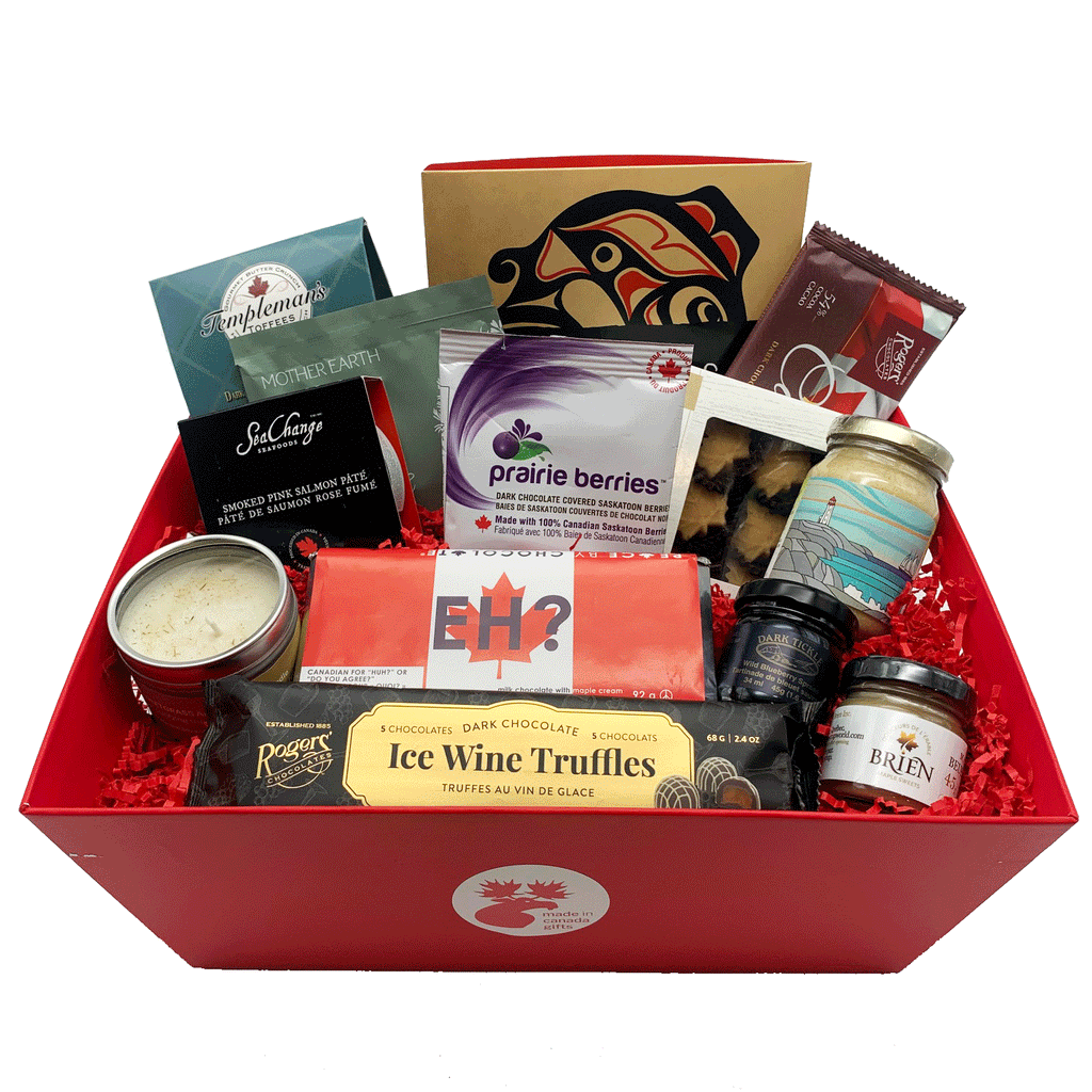 A large assorted Sea to Sea gift basket, featuring Canadian products made all across Canada. Items include smoked salmon, maple butter, various chocolates, candies, jam, gourmet Dijon mustard, First Nations tea and a candle.