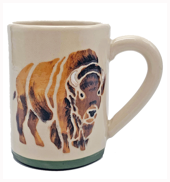 A handformed stoneware mug of white clay with ergonomic handle. The base is green and a bison is handpainted with a mixture of traditional brush and sgraffito on the side.