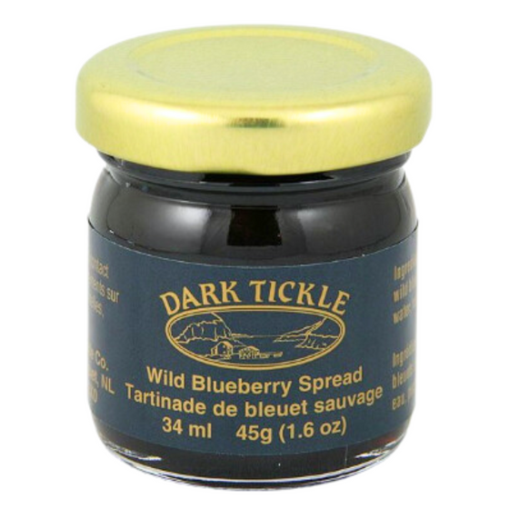 Small Glass Jar of Wild Blueberry Spread from Dark Tickle in Newfoundland. Jam is dark blue/ purple in color and is sealed with a gold tin lid.