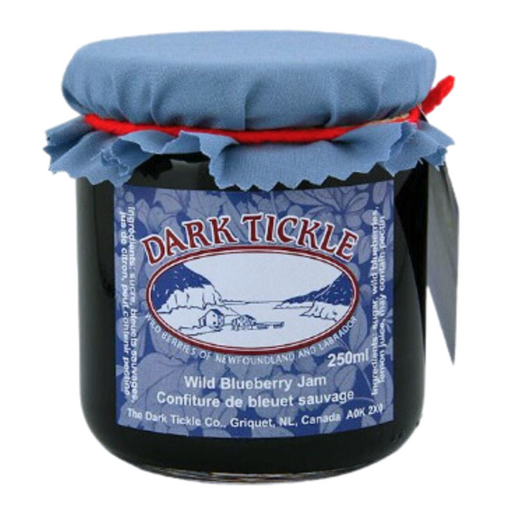 Glass Jar of Wild Blueberry Jam from Dark Tickle in Newfoundland. Jam is dark blue/purple in color, and shut sealed with a tin lid.
