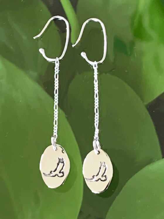 Drop earrings made of bright polished silver attached to sterling silver hooks.  The earrings are sterling ovals with a flying eagle etched in the centre.