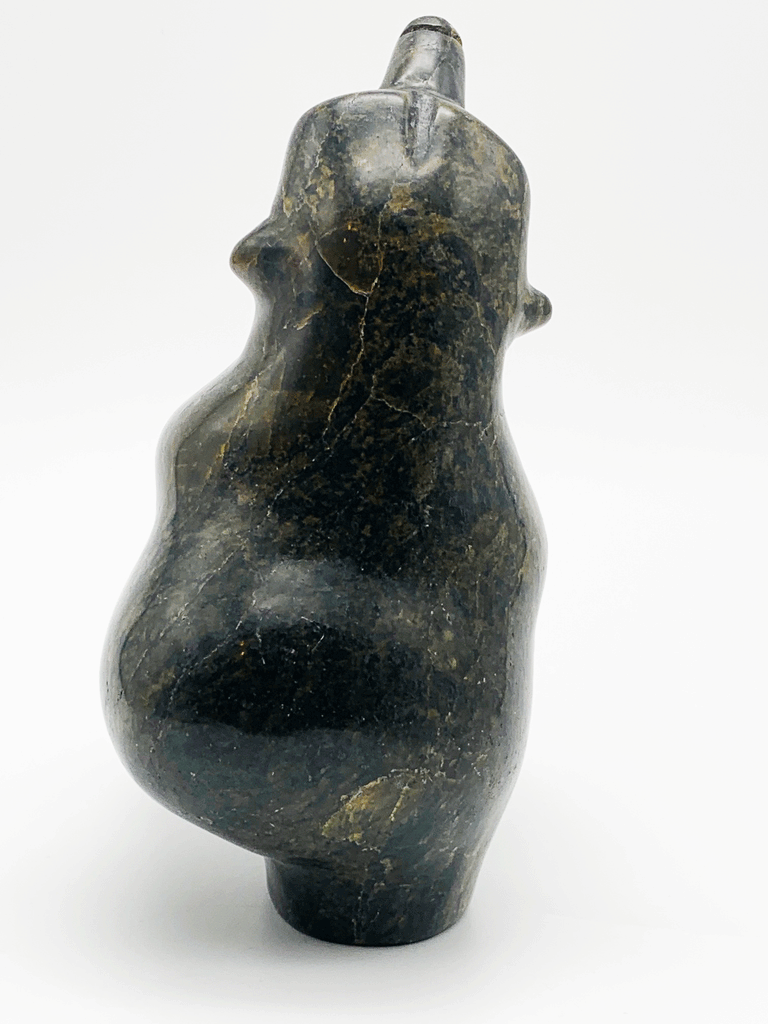 A dancing bear carved from greenish brown stone. This bear dances on one hind foot, with the other raised to one side and front paws raised. It throws its head back in jubilation. This bear faces away.