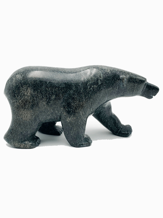 A powerful bear stands on all fours, carved from one piece of green soapstone. The bear faces right in this image.