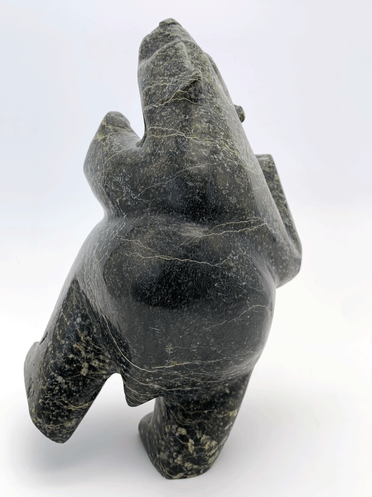 A dancing bear carved from jet black stone. This bear dances on one hind foot, with the other raised to one side and front paws raised. This bear faces left.