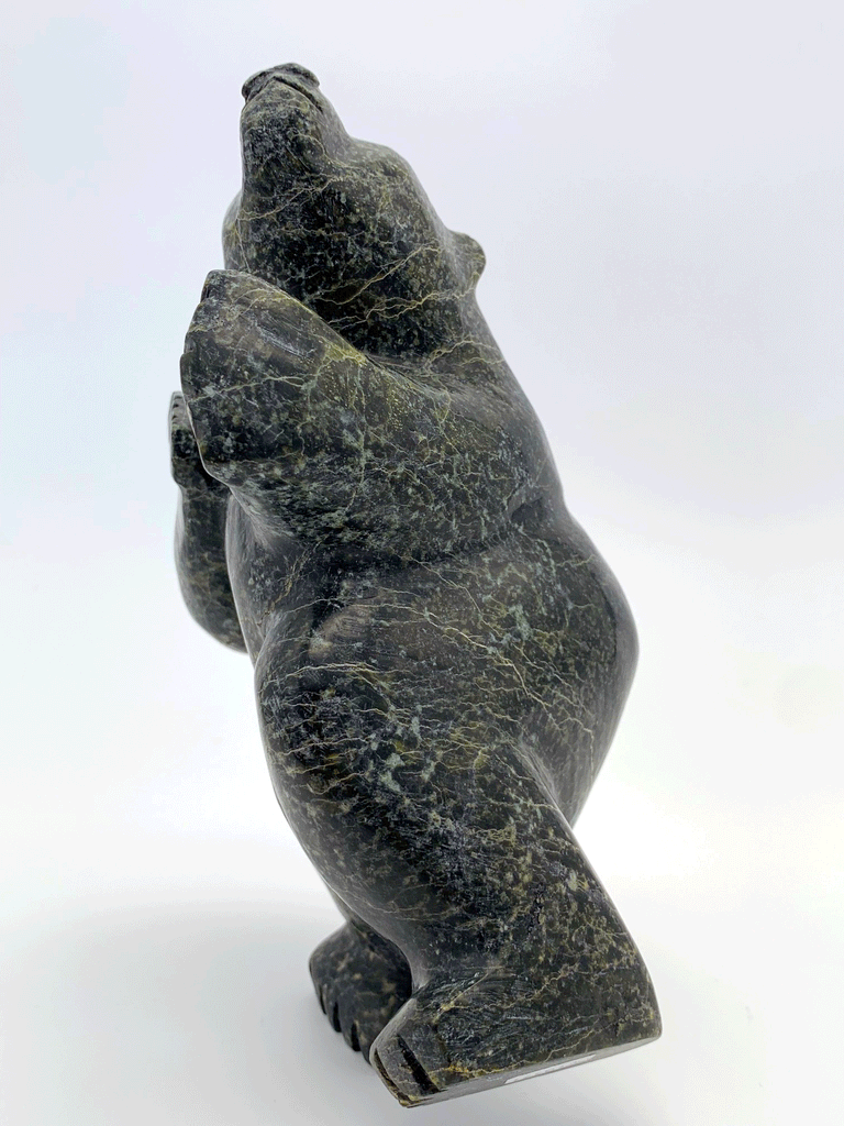 A dancing bear carved from jet black stone. This bear dances on one hind foot, with the other raised to one side and front paws raised. This bear faces the viewer.