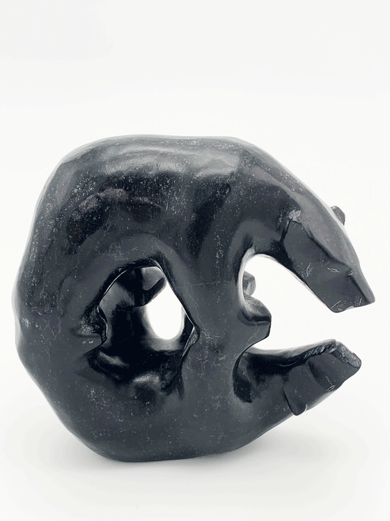 This carved black bear gazes thoughtfully at its reflection, also depicted in sculpture. The two bears stand on each other's four paws. This bear faces right.