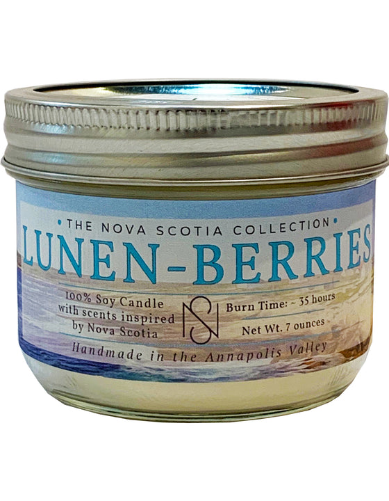 Cylindrical candle Jar with a tin cap. There is a label on the candle Jar, with a lake background, and Lunen Berries written in the middle.