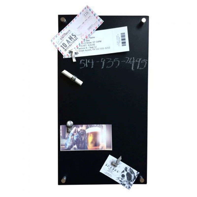 A tall rectangular black board is tacked to a white wall. Pewter light bulb, check-mark, and arrow magnets on the board  hold tickets, pictures, and a piece of chalk. A phone number is written on the board with chalk. 