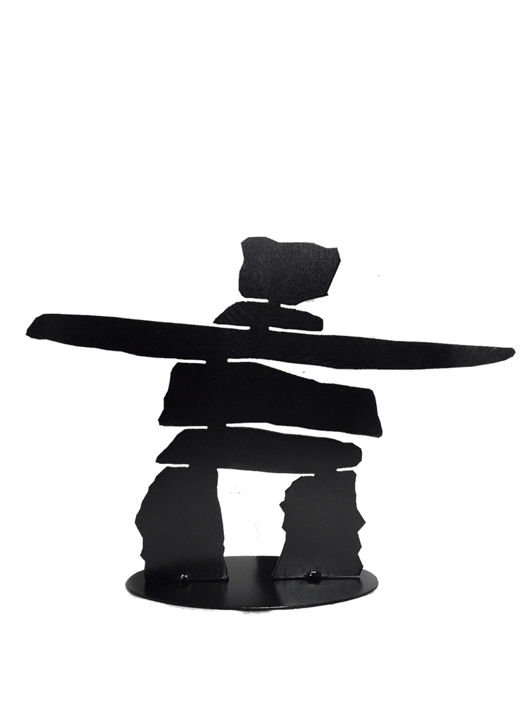 A laser-cut inukshuk silhouette in steel painted matte black. Its legs are soldered to a sturdy steel base, also painted black.