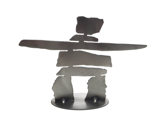 A laser-cut inukshuk silhouette in brushed steel. Its legs are soldered to a sturdy steel base.