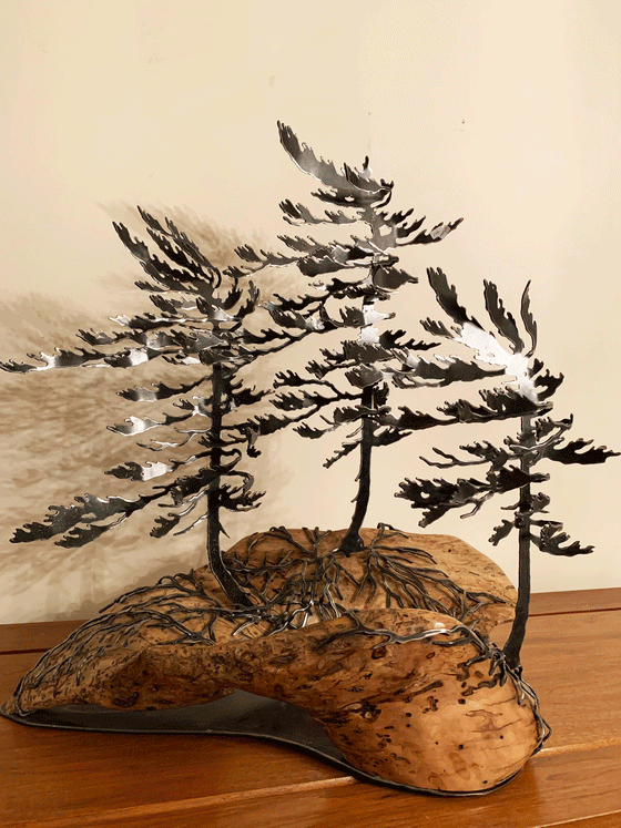 Steel windswept pine trees fitted onto a piece of Canadian polished wood. 