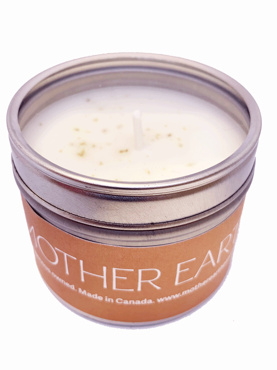 small circular tin candle. The Lid is transparent. The candle is wrapped in an orange label that says Mother Earth on It.