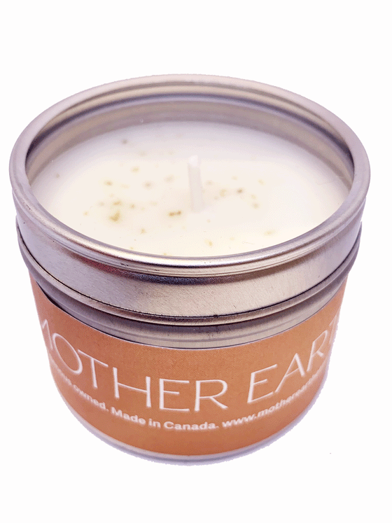 Small circular tin candle. The lid is transparent. The candle is wrapped in an orange label that says Mother Earth on It.