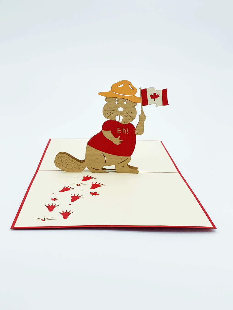 Inside of pop-up card. 3-D beaver wearing a red t-shirt that says "Eh!" and holding a Canadian flag. Beaver is wearing an mounties hat. Beaver foot prints are flat on the page. Footprints go from edge of the paper to wear the beaver is standing. 