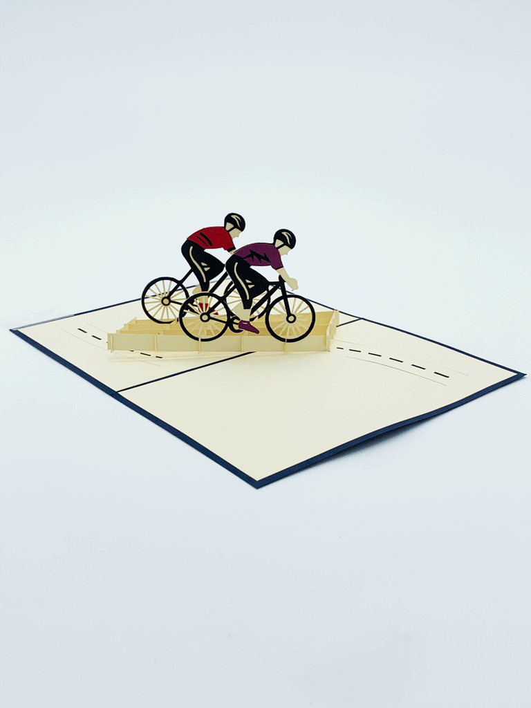 Inside of photo card. 3-D bikers, one is wearing a purple shirt and the other is wearing a red shirt. There is a bike lane flat on the page that goes from one side of the page to the opposite side of the page.