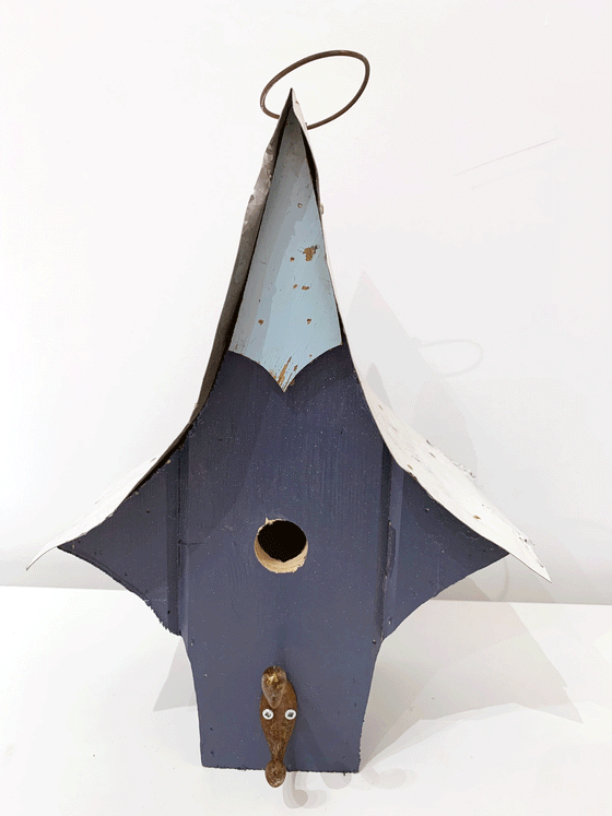 Beautiful handcrafted wooden bird house with a steel roof and vibrantly painted walls. 