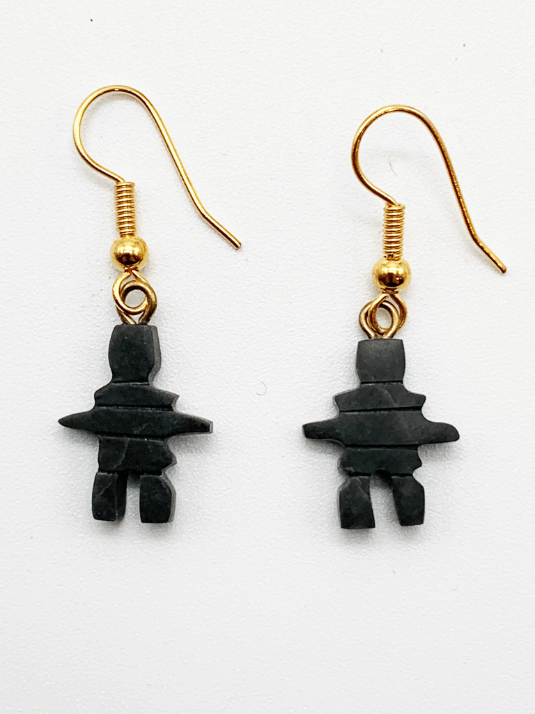 Dangling earrings featuring a small dark grey inuksuk hanging on a gold hook.