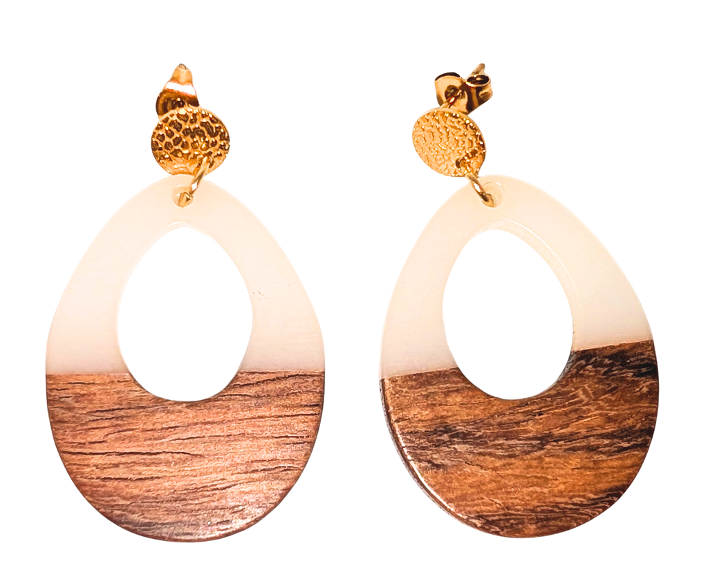 A pair of oval stud drop earrings with a  cutout in the middle. The top half is blue and the bottom is walnut wood. Hardware is gold.