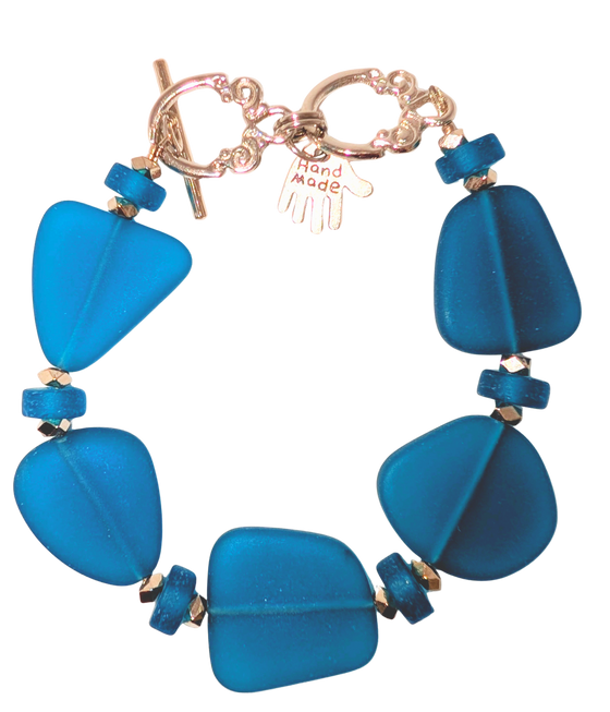 Bracelet with navy sea glass, beads, and a small hand charm that says "handmade" between 2 rings for sizing. The clasp is a silver toggle clasp.