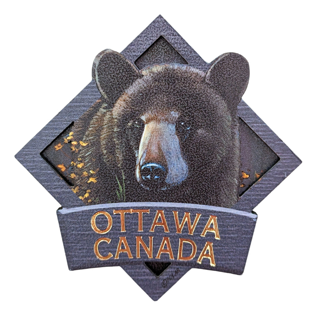 Indigo blue bordered diamond shaped wooden magnet. Vibrant Canadian black bear centered in a night covered forest. The bears ears embedded in the boarder above the edge. "Ottawa, Canada" in gold written underneath.