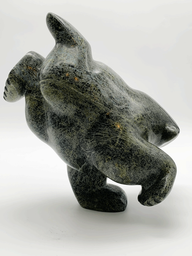 This large bear plunges into the water. The piece is balanced to stand on one forepaw, its other three legs are raised as though paddling. Its head strains as though reaching for a fish. This bear faces right.