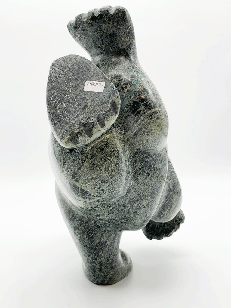 This large bear plunges into the water. The piece is balanced to stand on one forepaw, its other three legs are raised as though paddling. Its head strains as though reaching for a fish. This bear faces away.