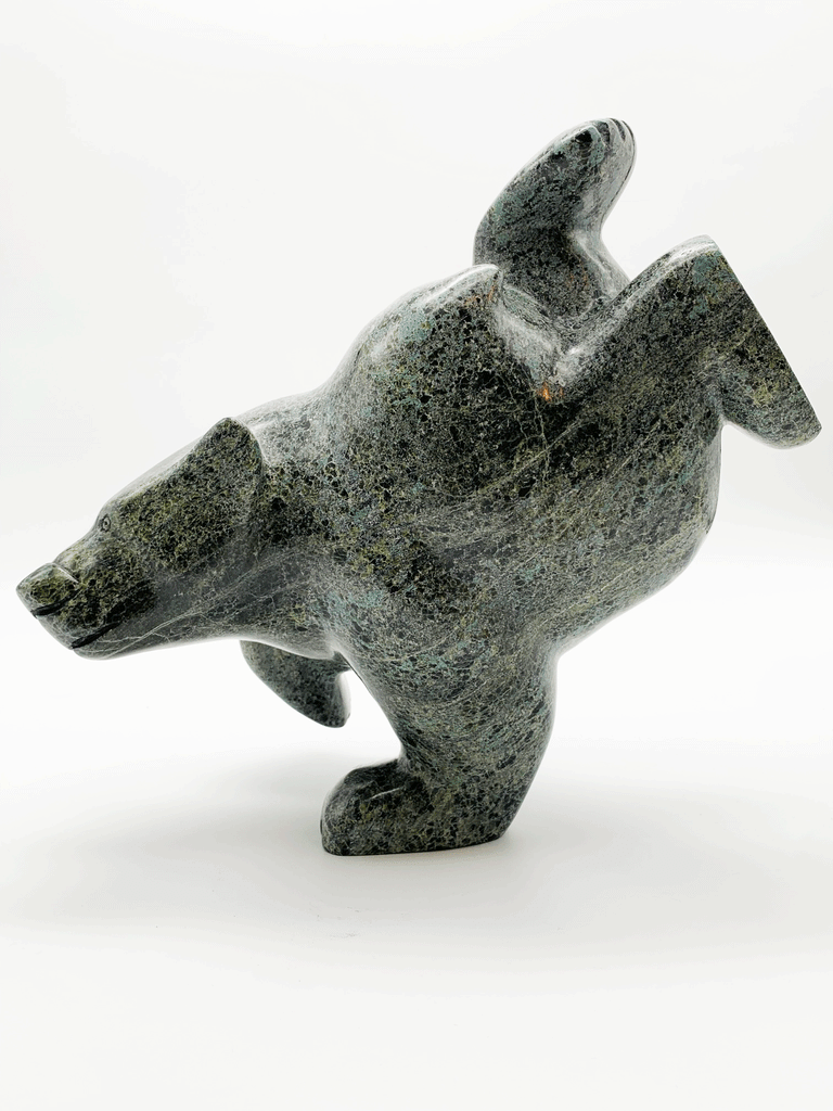 This large bear plunges into the water. The piece is balanced to stand on one forepaw, its other three legs are raised as though paddling. Its head strains as though reaching for a fish. This bear faces left.