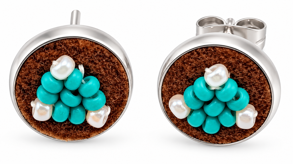 A pair of silver post earrings with round brown moose hide facepalm charms featuring blue and white beaded flower details, shown on a white background.