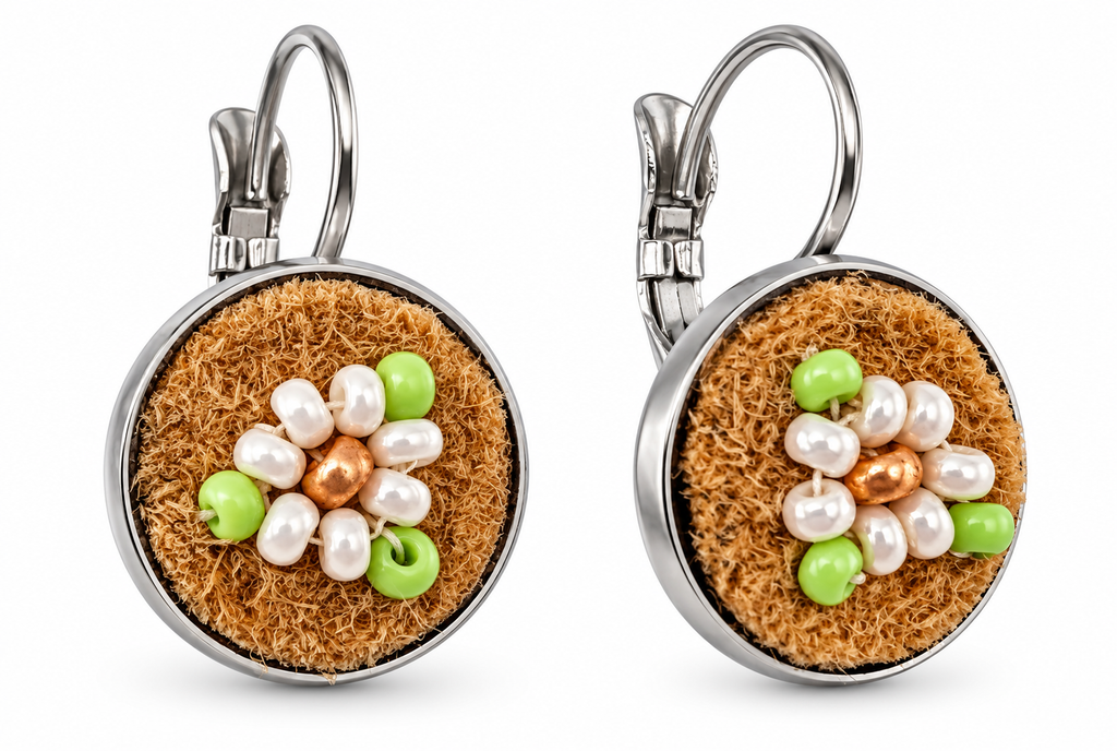 A pair of silver leverback earrings with round brown moose hide facepalm charms featuring white and bronze beaded flower details, shown on a white background.