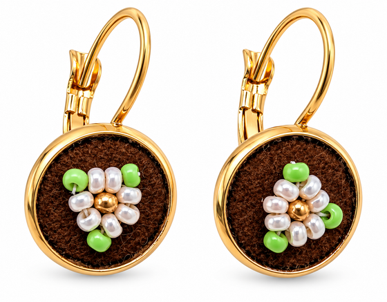 A pair of gold leverback earrings with round brown moose hide facepalm charms featuring white and green beaded flower details, shown on a white background.
