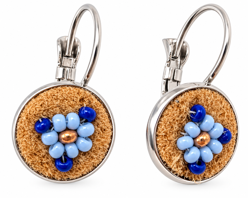 A pair of silver leverback earrings with round brown moose hide facepalm charms featuring blue and bronze beaded flower details, shown on a white background.