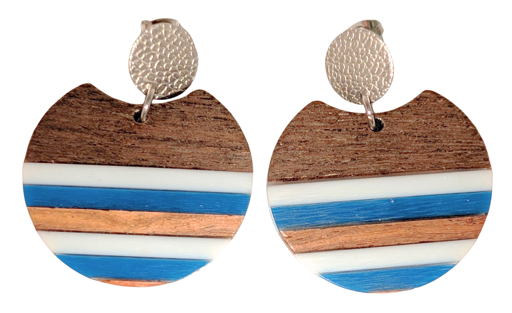 A pair of circular stud drop earrings with a stripes of white, blue, and walnut wood. Hardware is silver.