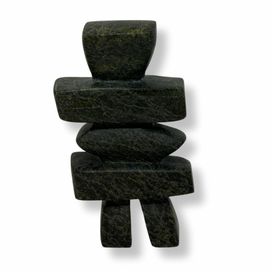 A squat, squarish inukshuk carved from green and black stone.