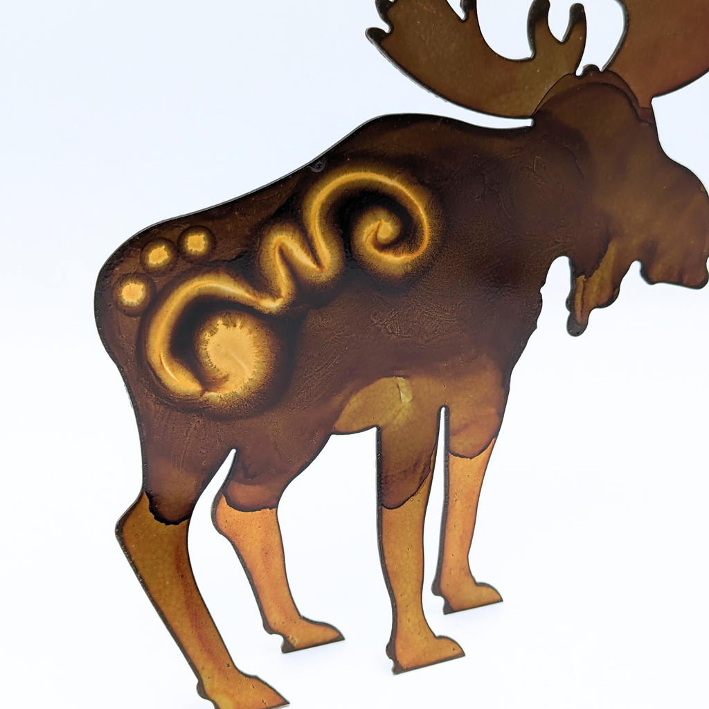 a hand painted brown metal moose with abstract waves painted on its back.