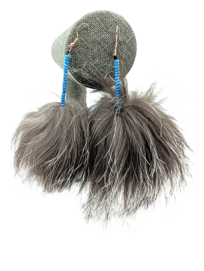Furry sealskin earrings in the shape of pompoms. Blue bead detailing.