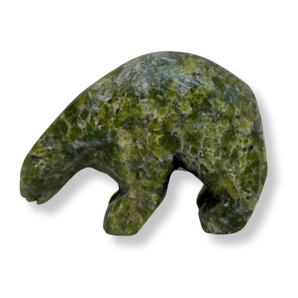 An inquisitive, bright green soapstone bear stands on all fours, head bowed as though examining something on the ground. This bear faces left.