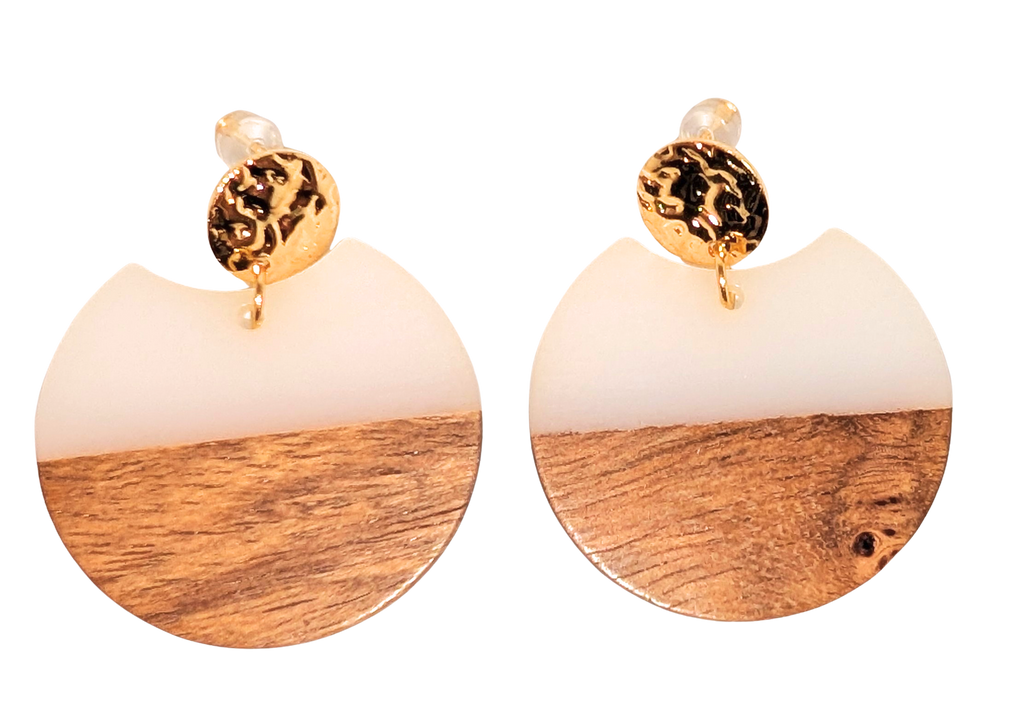A pair of circular stud drop earrings. The top half is white and the bottom is walnut wood. Hardware is gold.