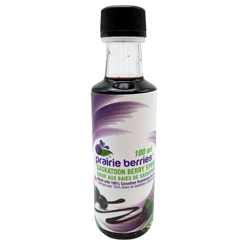 A bottle with a black cap depicting a white and purple label, featuring pictures of the Saskatoon berries and syrup.