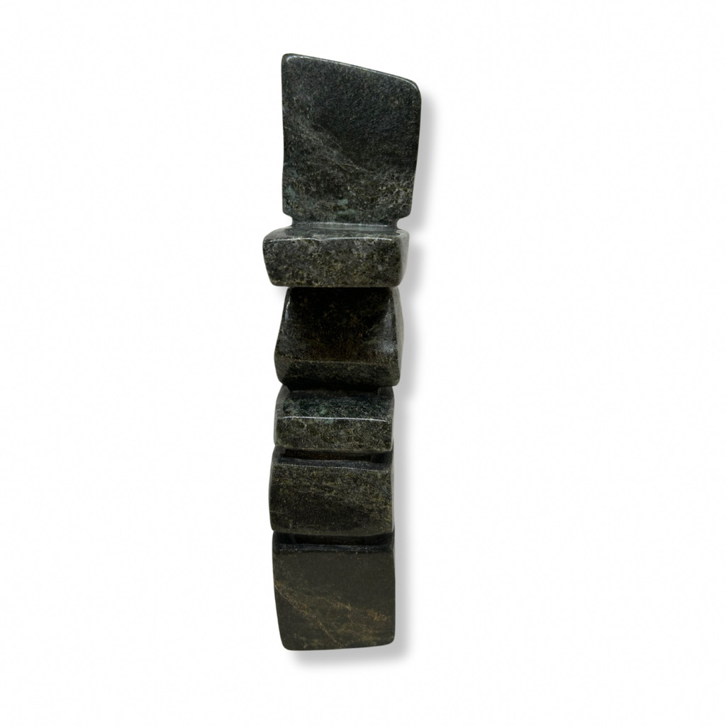 A graceful curving inukshuk carved from very dark green soapstone.