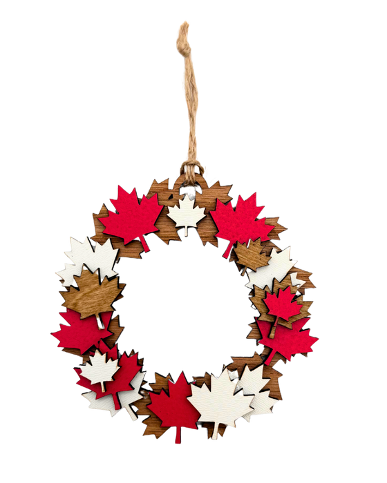 Ornament of a wreath made up of red, white, and brown maple leaves.